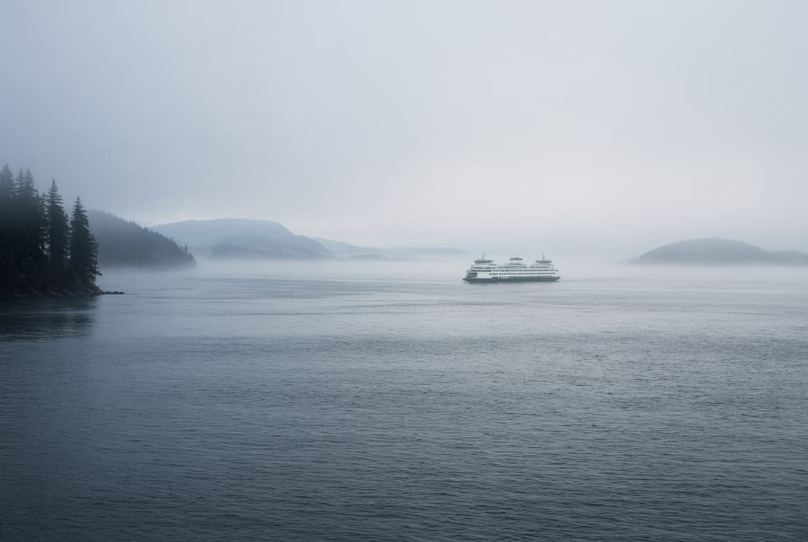 A Washington State ferry crossing Puget Sound in heavy fog, representing Apple Health enrollment in Washington