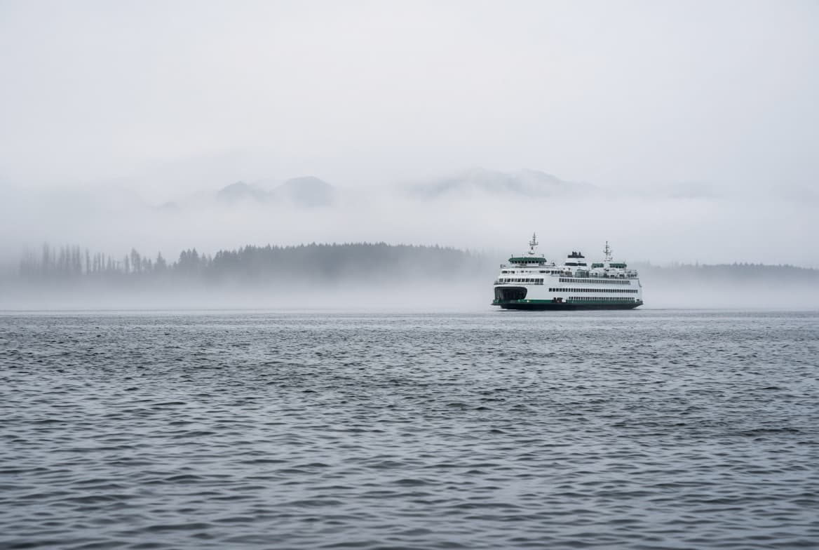 A Washington State ferry crossing Puget Sound in mist, representing the state-by-state differences in IOP billing