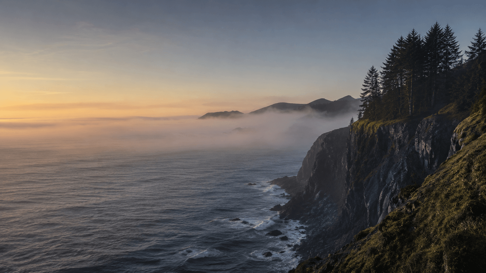 The Oregon coast at sunrise, with forested headlands above the Pacific
